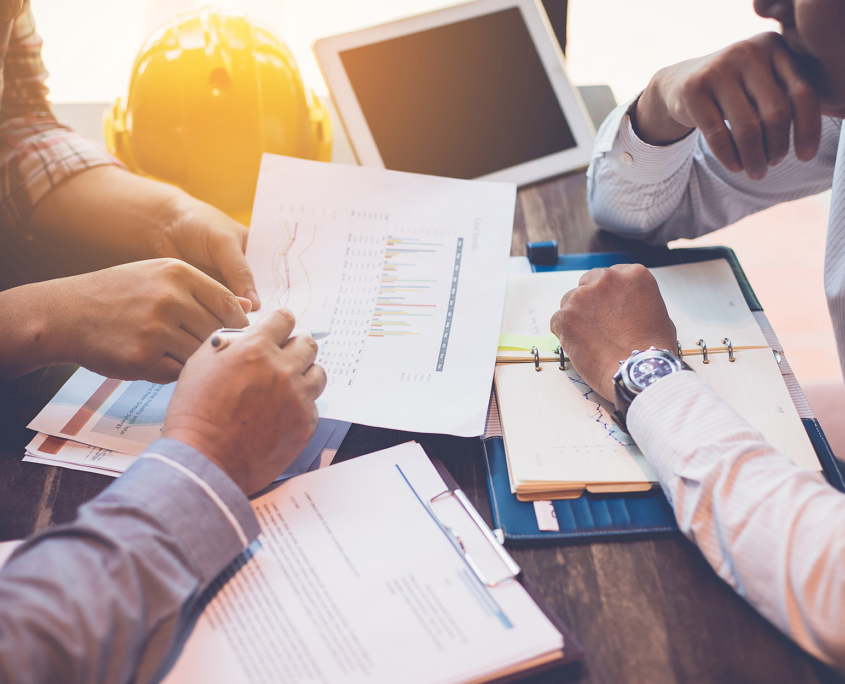 People at Meeting Table Looking at Financial Graphs