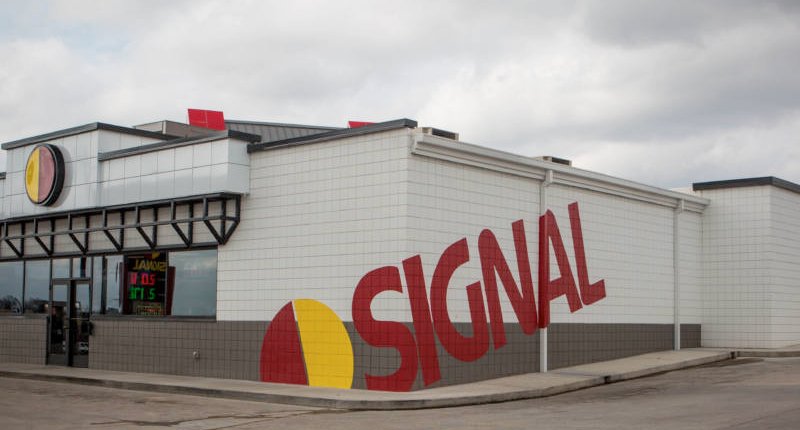 Updated SIGNAL convenience store with their logo large on side of the building and tile surrounding the exterior