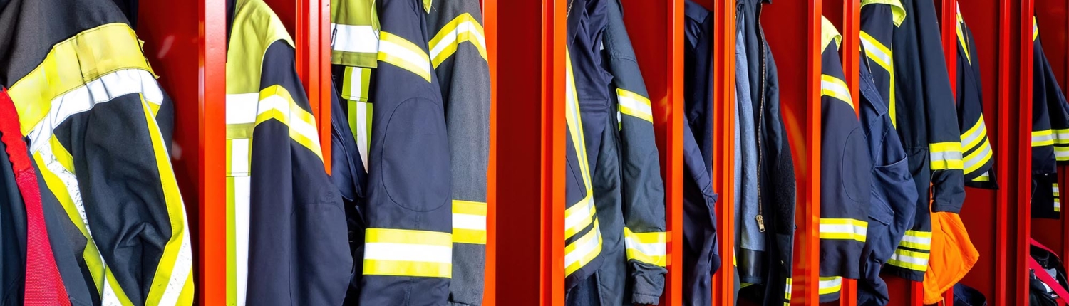 Side view of a row of uniforms at a fire station